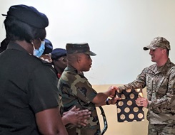 Ghana Armed Forces Brig. Gen. Nii Adjah Obodai, commander, 37th Military Hospital in Accra, Ghana, presents U.S. Air Force Tech. Sgt. Daniel Fisher, Defense Medical Readiness Institute’s Academic Support Branch noncommissioned-officer-in-charge, with a gift of appreciation for establishing a tactical combat casualty care training site in March 2022. (Photo: Terry J. Goodman)