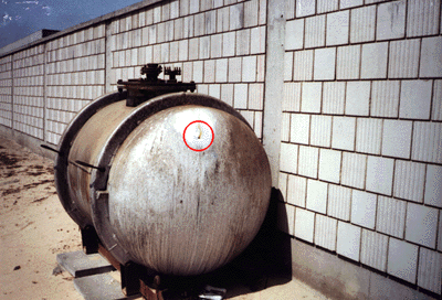 Figures 7 and 8. Photographs of the storage tank at the Kuwaiti Girls' School taken by the safety officer. Encircled area shows the movement of the fumes out of the bullet hole.