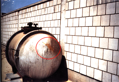 Figures 7 and 8. Photographs of the storage tank at the Kuwaiti Girls' School taken by the safety officer. Encircled area shows the movement of the fumes out of the bullet hole.