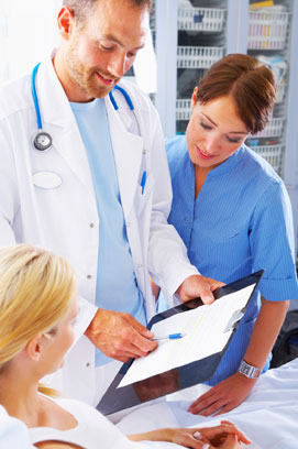 image showing a doctor and a nurse talking to a patient lying in bed.