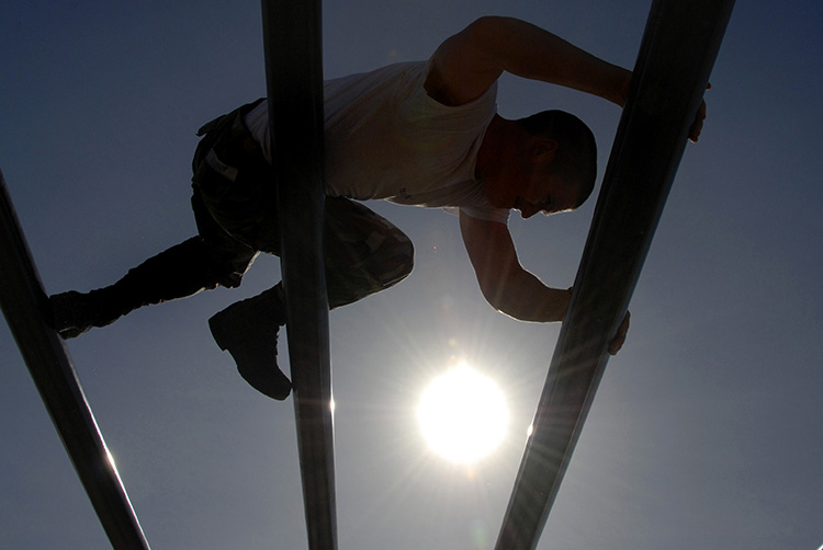 Image of A U.S. Navy Basic Underwater Demolition/SEAL student moves through the weaver during an obstacle course session in the first phase of training. (U.S. Navy photo by Mass Communication Specialist 2nd Class Kyle D. Gahlau/Released).