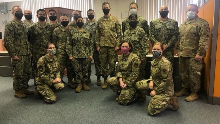 Image of A group of military personnel posing for a picture.