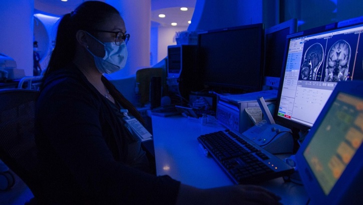 Image of Military medical personnel looking at a patient's brain scan.