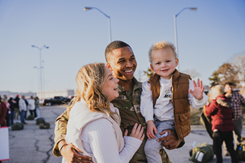 Soldier hugs his wife and young son