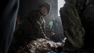 Link to Photo: U.S. Navy Hospital Corpsman 2nd Class Maliq Webster, assigned to the Whidbey Island-class dock landing ship USS Rushmore, performs critical medical care on a simulated patient during a tactical combat casualty care training exercise at Yokota Air Base, Japan, on April 3, 2025. Facilities on Yokota can recreate maritime-specific environments through training elements like smoke effects and low-light conditions, which provide sailors with realistic, shipboard-relevant training. (Photo by U.S. Air Force Senior Airman Samantha White)