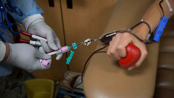 Image of US Marine Corps Lance Cpl. Angel Alvarado, a combat graphics specialist, donates blood for the Armed Services Blood Program.