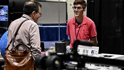 Kavan Paul speaks with a visitor to the Holistic Health and Fitness exhibit booth as part of the U.S. Army Medical Materiel Development Activity’s display during the Military Health System Research Symposium, Kissimmee, Florida, Aug. 16, 2023. (Photo by T. T. Parish)