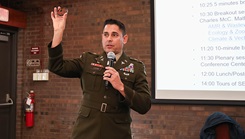 U.S. Army Col. Eli Lozano, commander of the Walter Reed Army Institute of Research (WRAIR), prepares to present WRAIR coins as a token of appreciation during the first plenary session of the third annual One Health Symposium at the Smithsonian Environmental Research Center (SERC) in Edgewater, MD, November 22, 2024. 