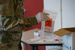 A COVID-19 test sample is packed into a box to be shipped for testing