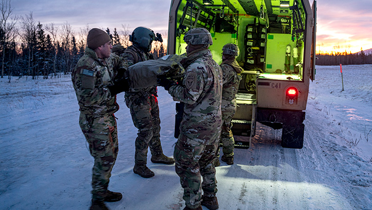 Soldiers move a simulated casualty into a field litter ambulance as part of a medical evacuation rehearsal