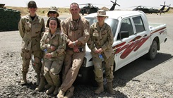 U.S. Air Force Col. Christopher Borchardt leans on a truck with members of the 506th EMEDS on the flightline, Kirkuk Air Base, Iraq, 2006.