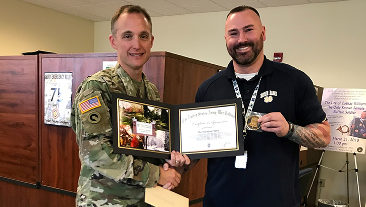 Image of Two men holding onto an award.