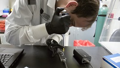 Medical personnel using a syringe to inject a fluid into a test tube