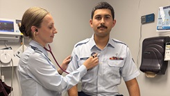U.S. Air Force Capt. Ashley Green, a physician assistant, holds a stethoscope to an Airman’s chest to demonstrate a routine checkup as part of her clinical duties