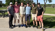 Six men standing shoulder to shoulder in golf attire.