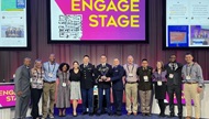 A group of smiling people standing on a stage after their program won the national cardiology knowledge bowl. 