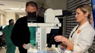 Cytopathology fellowship program director looks at a biopsy touch -preparation at the microscope with a cytopathology trainee during a Rapid On-Site Adequacy Evaluation (ROSE) in the Interventional Radiology Department.  