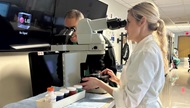 Cytopathology trainee gives his interpretation of a specimen at the double-headed microscope with faculty during a Rapid On-Site Adequacy Evaluation (ROSE) in the Interventional Radiology Department. 