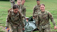 Emergency medicine resident physicians transport simulated patient during operational medicine day. 