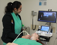 Endocrinology fellow practices a thyroid ultrasound on another fellow. 