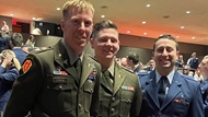 Three smiling fellows at graduation. 