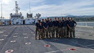 A group of residents pose on the flight deck of the USNS Mercy after assisting TDY on a medical mission.