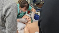 A resident practices intubation on a mannequin in the SIM center.