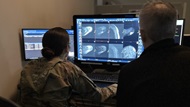 A fellow engages in imaging readout with faculty. 