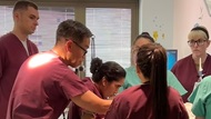 A neonatologist provides guidance as a resident prepares to intubate a baby. 