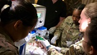 Members of a neonatal transport team practice intubation of a mannikin during a transport simulation exercise. 