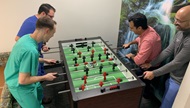 Four fellows playing foosball. 