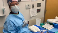 An Ob-Gyn resident poses in scrubs prepping for surgery.  