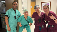 Four smiling Ob-Gyn residents in the hallway. 