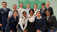 A group of Ob-gyn residents and faculty smiling during a conference. 