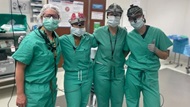 A team of Otolaryngology residents and faculty members pose in the operating room. 