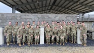 Interns pose in a group outside of the Leadership Reaction Course at Camp Bullis. 