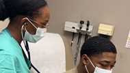 Intern practices a medical check-up on a fellow soldier. 