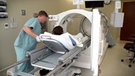 A staff member places a patient into the single hyperbaric oxygen chamber at the Undersea & Hyperbaric Medicine Clinic at Brooke Army Medical Center. Hyperbaric oxygen is an intervention in which an individual breathes nearly 100 percent oxygen while inside a hyperbaric chamber that is pressurized to greater than sea level pressure.