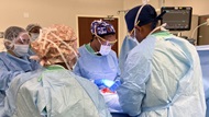 Urology residents and support team performing a surgical procedure in the operating room. 