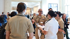 Defense Health Network Pacific Rim Director Rear Adm. Guido Valdes talks with a group of residents from Naval Medical Center San Diego at the 2024 Military Health System Research Symposium in Kissimmee, Fla. Valdes, who is also the Naval Medical Forces Pacific commander, was at the event to support presenters from military treatment facilities within his Network as well as those from Navy Medicine’s eight medical research laboratories which fall under his purview. (Department of Defense photo by Regena Kowitz/Released)