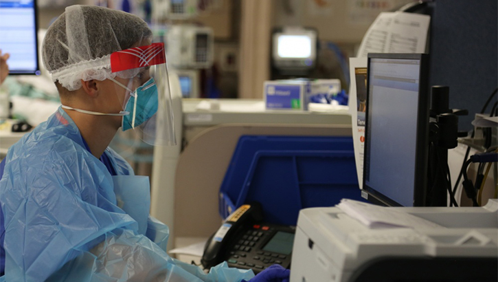 Image of Military health personnel inputting information into a computer.