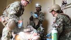 U.S. Navy Lt. Joshua Grimes (left), physician assistant, U.S. Navy Lt. j.g. Ashton Hartwell (right), emergency room nurse, and respiratory technician U.S. Navy Hospital Corpsman 2nd Class Nya Jobs (center) with Expeditionary Resuscitative Surgical System prepare to put a splint on a simulated high-fidelity manikin during a course at Naval Expeditionary Medicine Warfighter Development Center