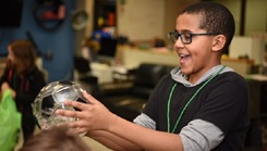 son of military personnel playing with a piggy bank