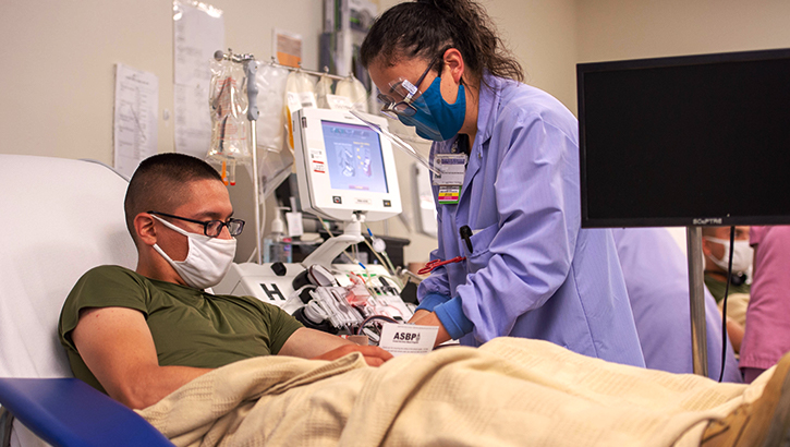 Image of a nurse helping a COVID-19 patient.