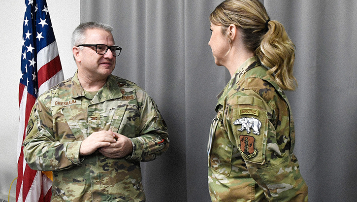 U.S. Air National Guard Master Sgt. Seana O'Kelley-Hooker, senior noncommissioned officer in charge of medical administration for the 168th Medical Group, receives a commander’s coin from U.S. Air Nation Guard Col. Michael Griesbaum  in recognition of her quick and decisive actions in response to a recent rollover incident on the highway in Fairbanks, Alaska. O'Kelley-Hooker's experience and training fueled her to help a person she had witnessed roll over while driving to work. (Photo by U.S. Air National Guard Senior Master Sgt. Julie Avey)  