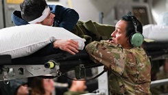Air Force Staff Sgt. Michelle Chiaravalle, 60th Aeromedical Evacuation Squadron aeromedical evacuation technician, talks with Marine Corps Cpl. Daniel Sanchez, with the Combat Logistics Regiment 3, while flying over the Pacific Ocean during exercise Ultimate Caduceus 2024, June 17, 2024. (Photo By Petty Officer 1st Class Anita Chebahtah)