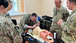 Military medical personnel discuss proper airway clearance procedures and intubation in operating room