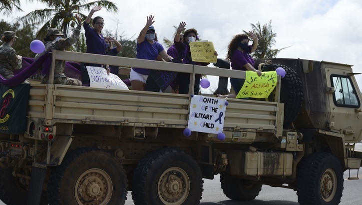 Image of Military personnel wearing face mask in the back of a truck.