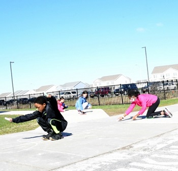 Image of Children writing on the sidewalk with chalk.