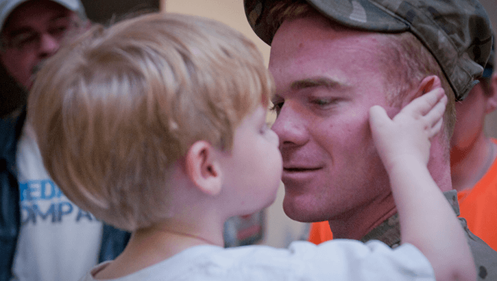 Image of A child holding his dad's face.